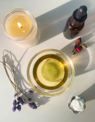 Massage Therapy image of oils, a candle, and some dried flowers